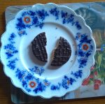 last biscuit broken in half on a plate with crumbs